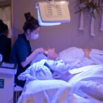 Een vrouw ondergaat LED lichttherapie voor verbeterde huidtextuur en vermindering van huidproblemen.